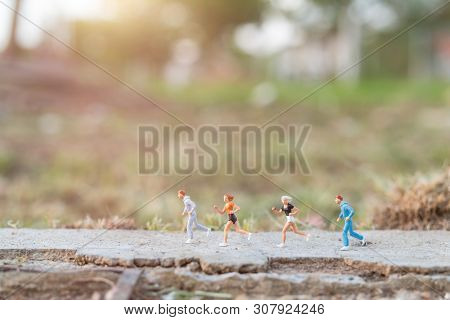 Miniature People : Running On The Road With Nature Background , Health And Lifestyle Concepts