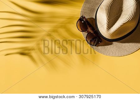 Hat And Glasses On Bright Yellow Background With Tropical Leaf Shadow, Creative Pastel, Beach Concep