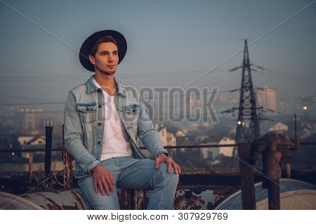 Urban Man With Hat Against The Background Of The City. Cool Guy. Wearing White Shirt And Jeans. Old 