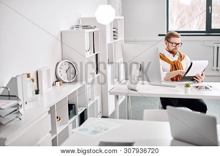 Mid Age Businessman Working With Dokuments At The Computer In Office