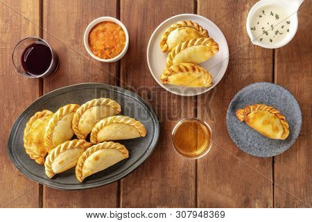 Empanadas With Sauces And Wine, Shot From The Top On A Dark Rustic Wooden Background