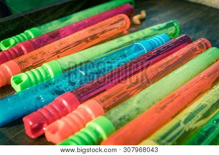 Filtered Image Colorful Stack Of Plastic Bubble Wands On Wooden Background Close-up
