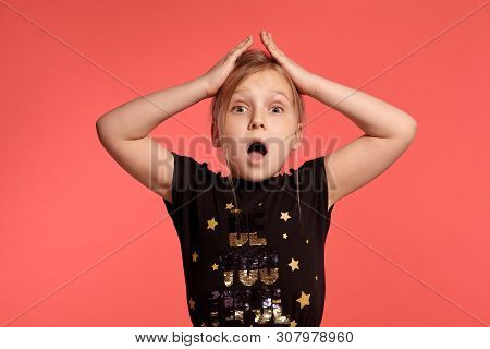 Close-up Shot Of A Charming Blonde Little Lady In A Combined Dress Posing Against A Pink Background.