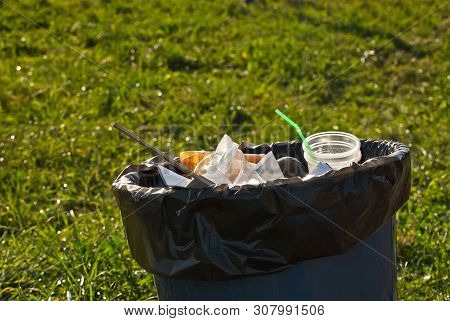 Blue Litter On Green Grass. Garbage In The Nature After The Concert.