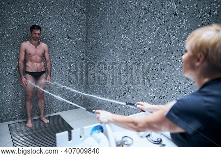 Smiling Lean Young Man Enjoying Charcot Douche