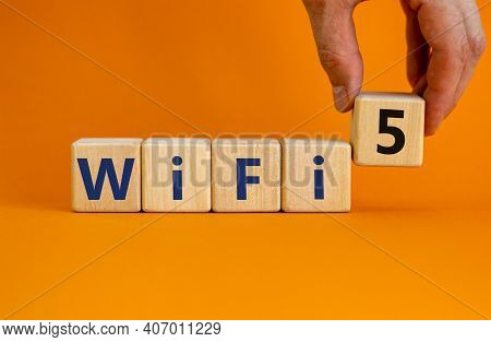 Wifi 5 Symbol. Businessman Holds A Wooden Cube With Words Wifi 5. Beautiful Orange Background, Copy 