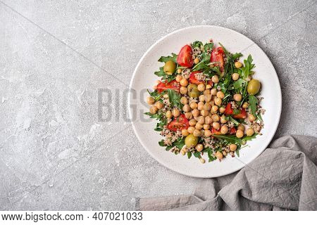 Healthy Vegetarian Salad With Cooked Chickpeas, Chia Seeds, Fresh Arugula, Cherry Tomatoes And Olive