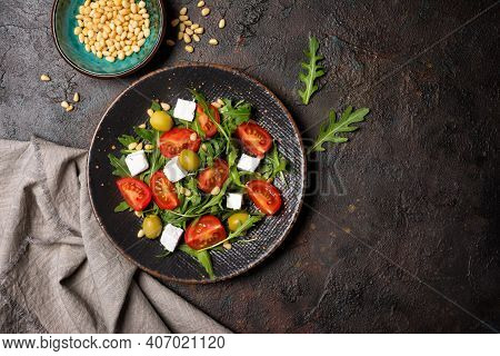 Healthy Vegetarian Salad With Fresh Arugula, Cherry Tomatoes, Soft Cheese, Olives And Pine Nuts