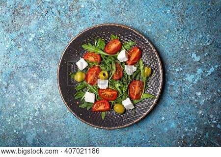 Healthy Vegetarian Salad With Fresh Arugula, Cherry Tomatoes, Soft Cheese And Olives