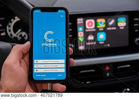 Citymove App On The Screen Of Smart Phone In Mans Hand On The Background Of Car Dashboard Screen Wit