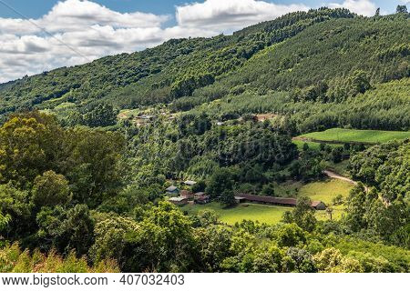 Dirty Road And Farms With Forest Around