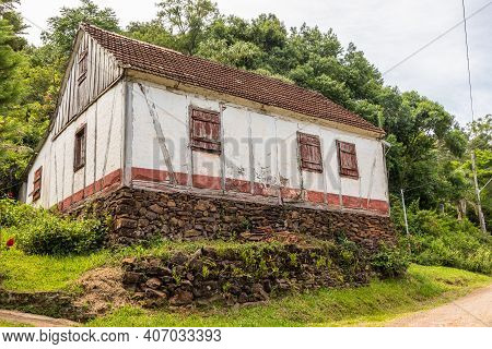 Small House In Enxaimel Style, Dirty Road With Flowers And Plants Around