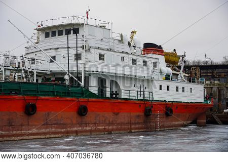 Old Rusty Motor Ship. Volgograd. Krasnoarmeysky Zaton, Wintering Of Ships On A Frozen River.