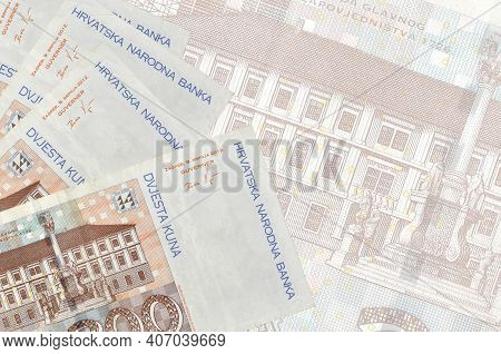 200 Croatian Kuna Bills Lies In Stack On Background Of Big Semi-transparent Banknote. Abstract Busin