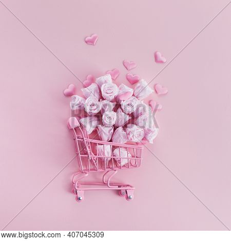 Shopping Cart With Pink Roses And Hearts On Pink Background. Romanitc Concept