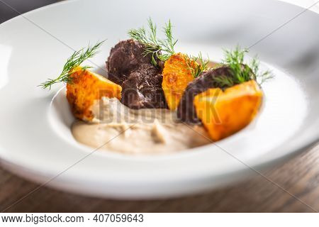 Cooked Pork Jowl Or Oxcheek Served With Mashed Celery And Baked Sweet Potatoes.