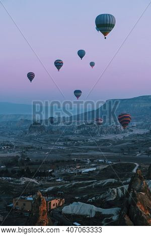 Hot Air Balloon Flying Over Rock Landscape At Cappadocia Turkey. Vertical Image.