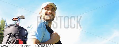 Portrait Of Male Golfer Carrying Golf Bag While Walking By Green Grass Of Golf Club.