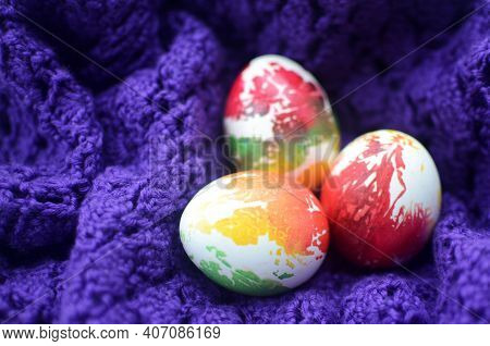 Three Decorated Multi-colored Red, Orange, Yellow, Green Chicken Easter Eggs Wrapped In A Knitted Pu