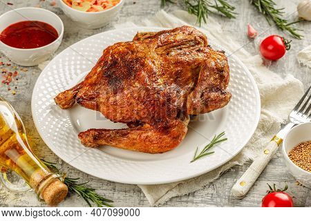 Tasty Grilled Fried Roast Chicken Tabaka In A White Plate On Concrete Table With Wegetables And