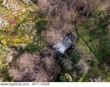 Aerial View Of A Mountain Stream Rushing Through A Woodland And Cascading Over A Waterfall Near Feli