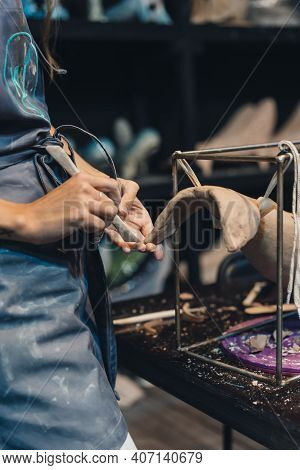 Close-up View Of Female Hands Gently Handling A Clay Whale In Workshop.