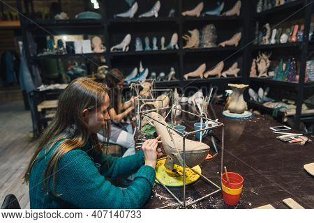 People Carefully Work On Clay Whales In Workshop