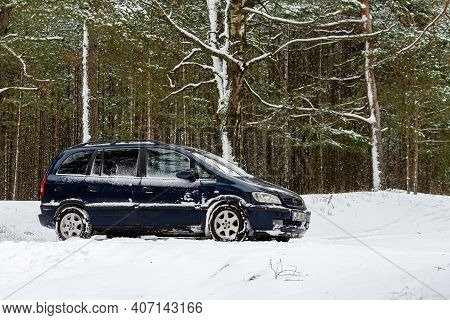 Riga, Latvia - January 30, 2021: Blue Car Opel Zafira Parked In The Winter Forest