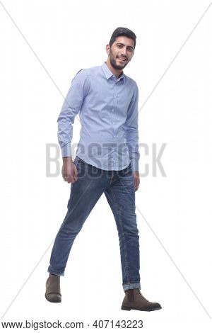 confident young man in jeans striding forward.