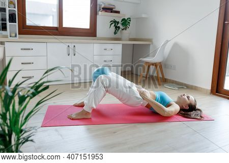 Portrait Of Fit And Healthy Gym Woman With Small Pilates Ball Making Exercise On Yoga Mat At Home,he