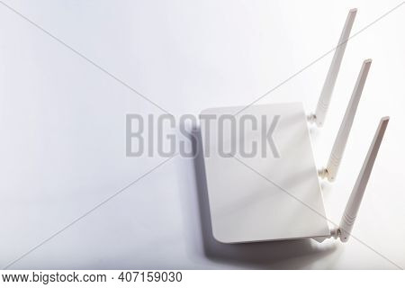 White Wifi Router With Three Antennas On A White Background With Copy Space.