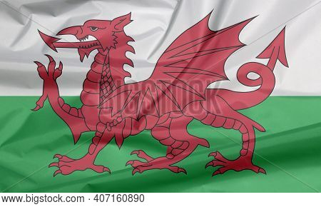 Fabric Flag Of Wales. Crease Of Wales Flag Background, Consists Of A Red Dragon Passant On A Green A
