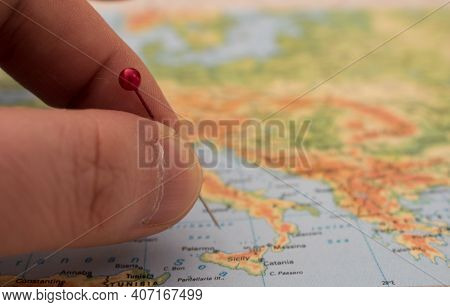 Close Up On A Hand Placing A Pin On A Map Of Europe