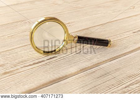 A Magnifying Glass On A Wooden Table. The Concept Of Information Search. Selective Focus