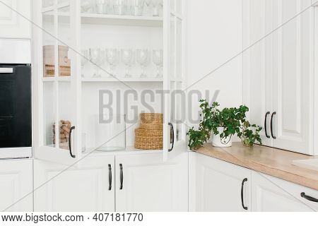 Opened White Glass Cabinet With Clean Dishes And Decor. Scandinavian Style Kitchen Interior. Organiz