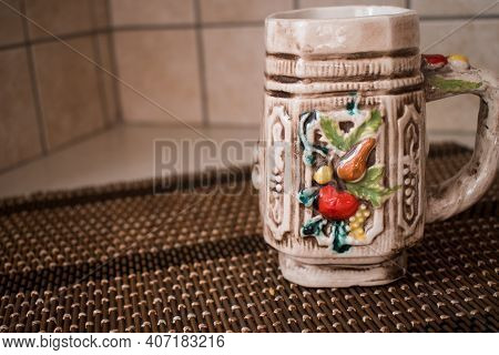 A Colorful Ceramic Empty Mug For Coffee Or Tea On Wicker Surface. Home Interior.