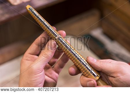Male Hands Of A Jeweler Who Measures The Size Of A Ring Using A Ring Gauge
