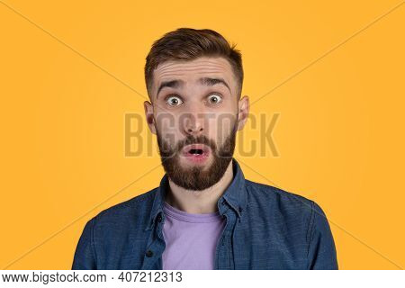 Unbelievable News. Portrait Of Bearded Young Guy Opening His Mouth And Eyes In Shock, Looking At Cam