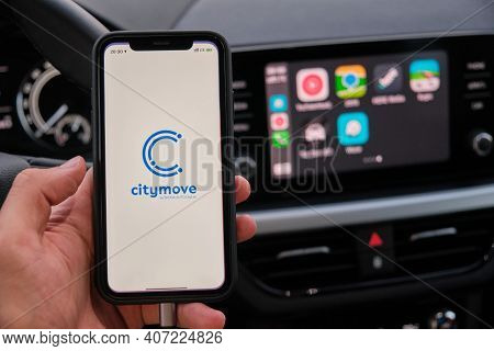 Citymove On The Screen Of Smart Phone In Mans Hand On The Background Of Car Dashboard Screen With Ap