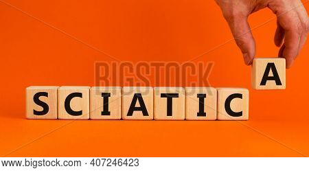 Sciatica Symbol. Wooden Cubes With Word 'sciatica'. Doctors Hand. Beautiful Orange Background. Medic
