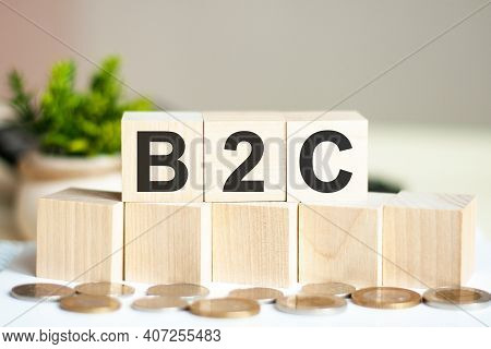 Concept Words B2c On Wooden Blocks On Beautiful Background. The Word B2c On Wood Cubes With Coins On