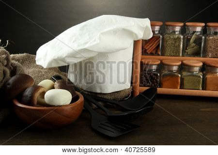 Sammansättning med kockens hatt och kitchenwear på bordet på grå bakgrund