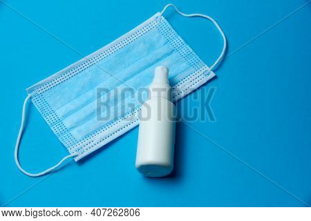 Medical Mask With A Disinfectant Bottle On A Blue Background