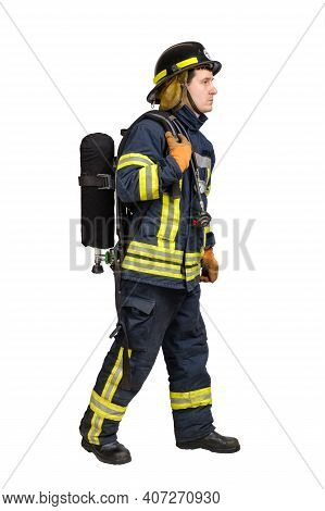 Full Body Young Caucasian Man In Uniform Of Fireman Goes Away In Profile With Air Cylinder Assembly 