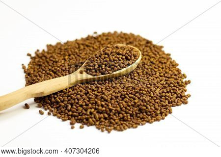 Buckwheat Tea In A Wooden Spoon On A White Background. Isolate. Buckwheat Tea Close-up Macro Photogr