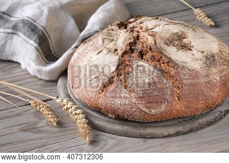 No Knead Handmade Loaf On Cutting Board On Wood With Linen Towel, Spelt Ears. German Bauernbrot Mean