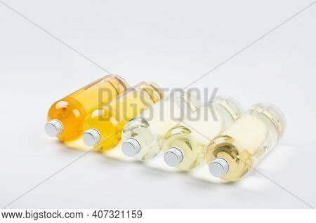 Collection Transparent Lying Bottles With Different Pale Colors Liquid, Cosmetic Product, Perfume Or