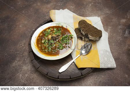 Homemade Thick Soup Kharcho With Beef And Tomato Paste Is Poured Into A Plate, Next To It There Is B