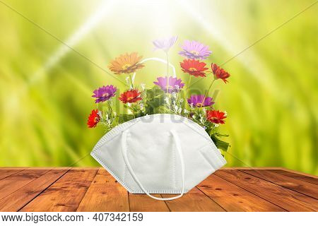 Kn-95, Ffp2 Face Mask As A Basket With Bouquet Of Flowers On A Wooden Table On A Sunny Day In The Fi