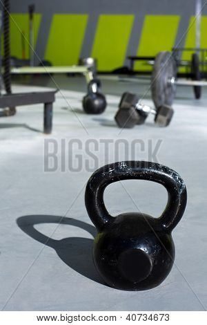 Kettlebell in Turnhalle mit Traglasten von Balken im Hintergrund